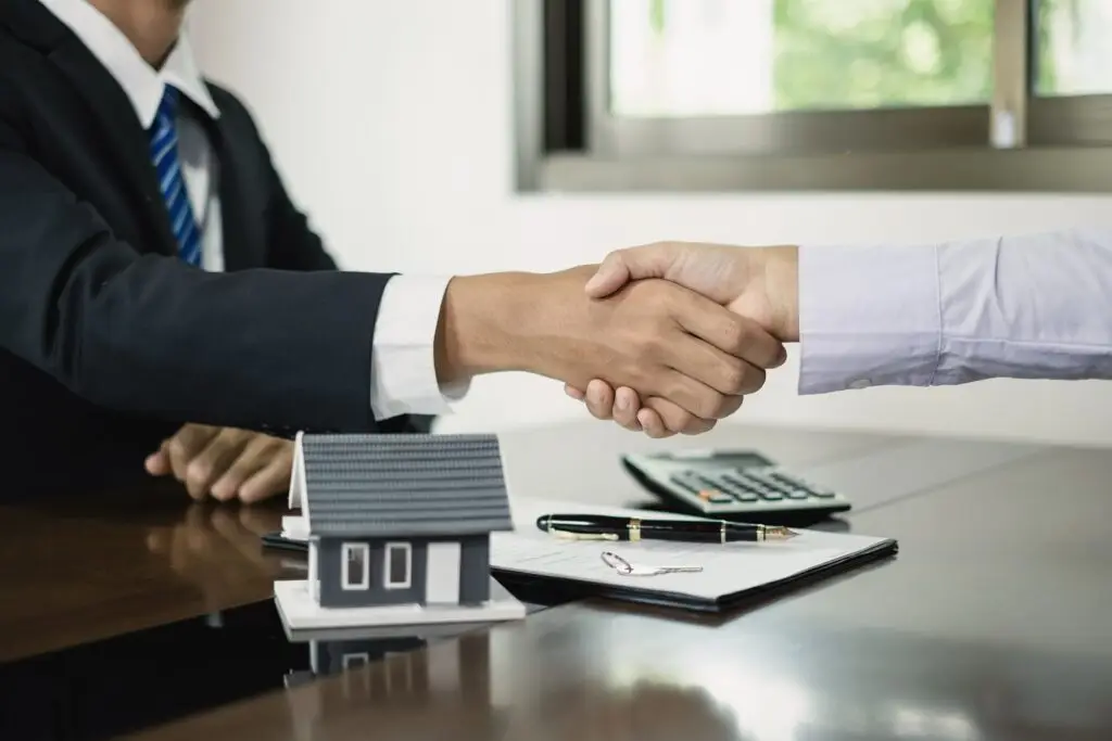 Homebuyer smiling while signing mortgage documents with TechLoans' fast and affordable services.